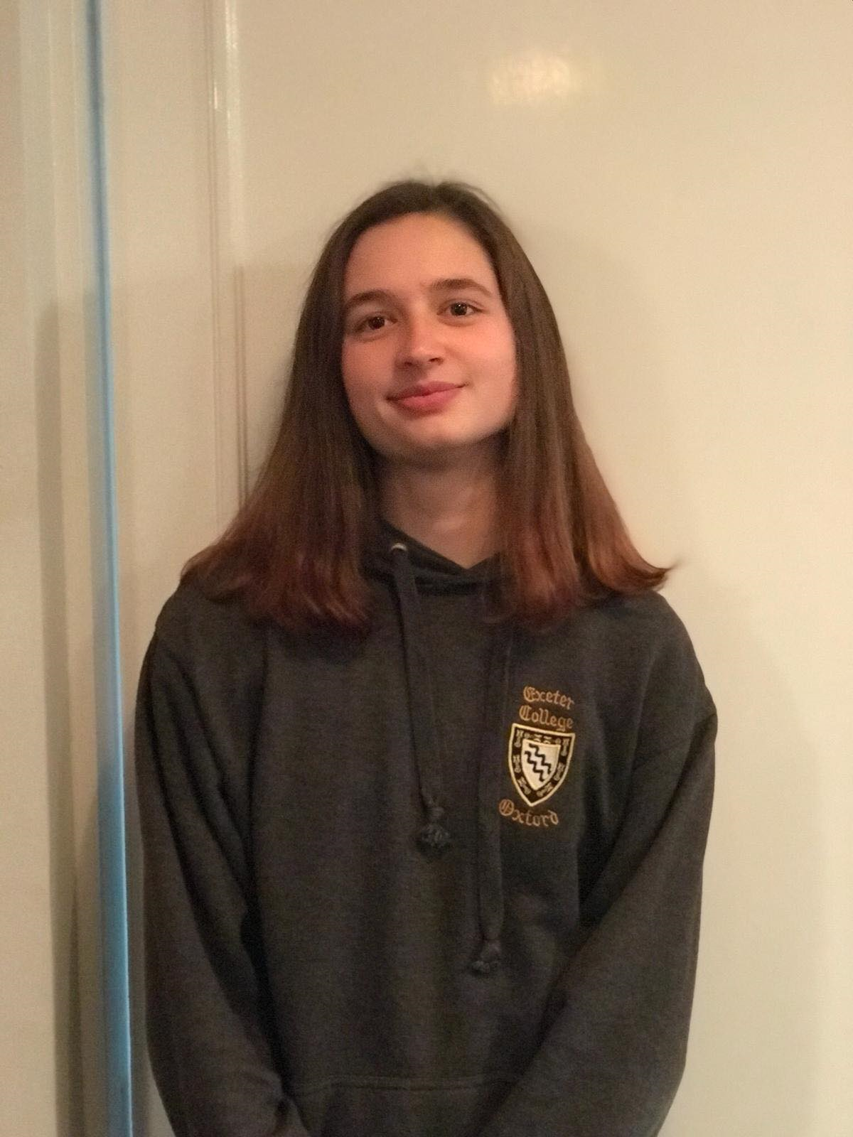 Bethany, smiling and wearing an Exeter College hoodie